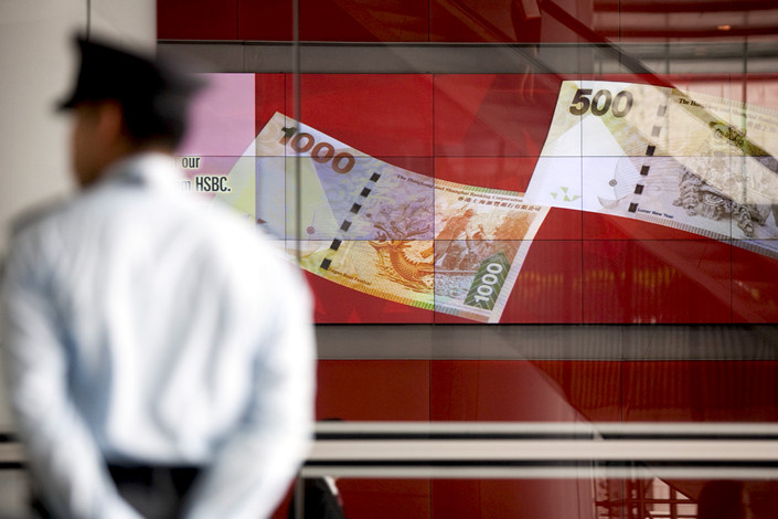 A security guard stands next to a billboard showing Hong Kong’s currency at HSBC Holdings’ headquarters in Hong Kong on Aug. 2. Photo: VCG
