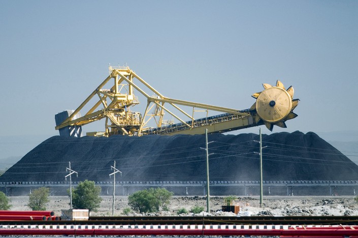 A loading machine towers above an enormous mound of coal at the Port of Newcastle, north of Sydney, Australia. Photo: VCG