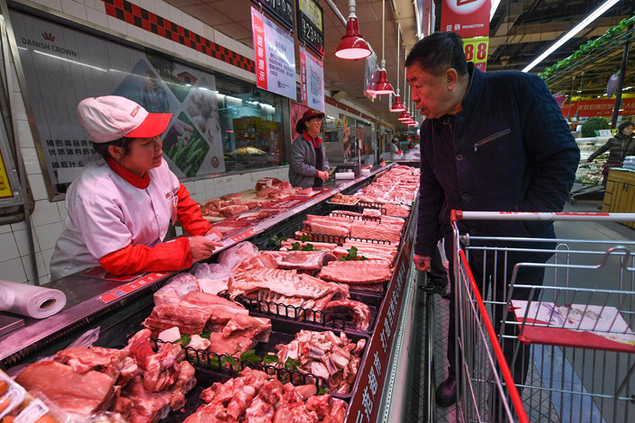 A shopper buys pork at a supermarket in the northern city of Taiyuan on Jan. 10. Photo: VCG