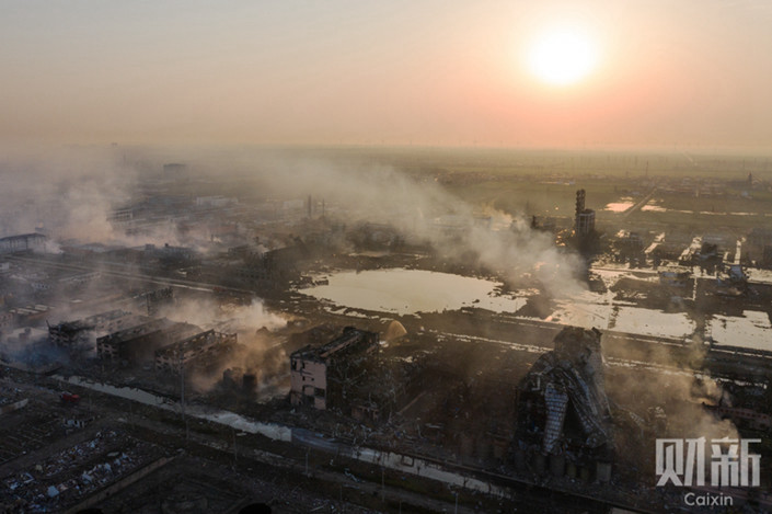 At the explosion site 40 hours after the blast, smoke continues to rise around the crater. Photo: Liang Yingfei/Caixin