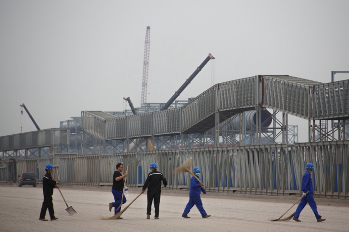 Workers walk in front of a steel plant at the Tangshan Fengnan Economic Development Zone, Hebei province, August 22, 2018. Photo: VCG