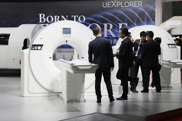 Visitors examine CT scanners at a medical equipment exhibition in Beijing in August 2017. Photo: VCG