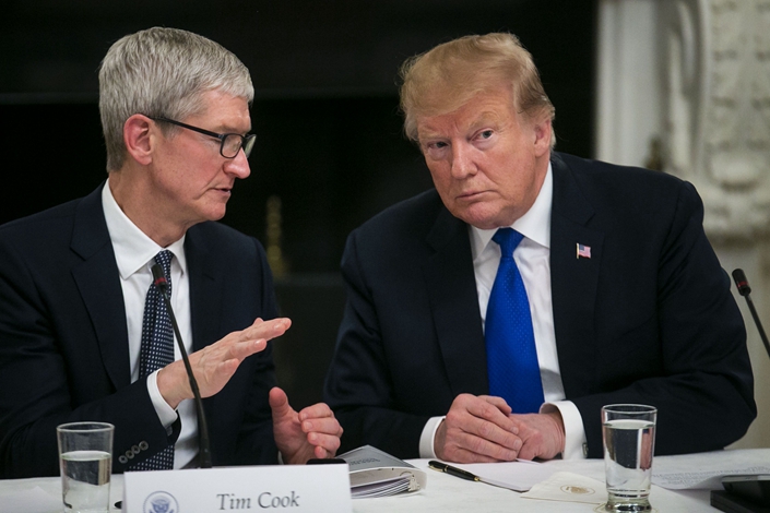 U.S. President Donald Trump speaks with Tim Cook, CEO of Apple Inc., in the State Dining Room of the White House in Washington, D.C. on March 6. Photo: Bloomberg