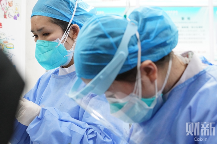 Doctors in protective clothing treat patients in Wuhan, Jan. 22. Photo: Cai Yingli/Caixin
