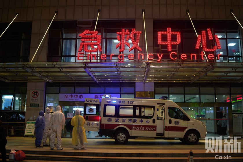 Hospital workers wait for the next ambulance outside the hospital’s emergency room. Photo: Ding Gang/Caixin