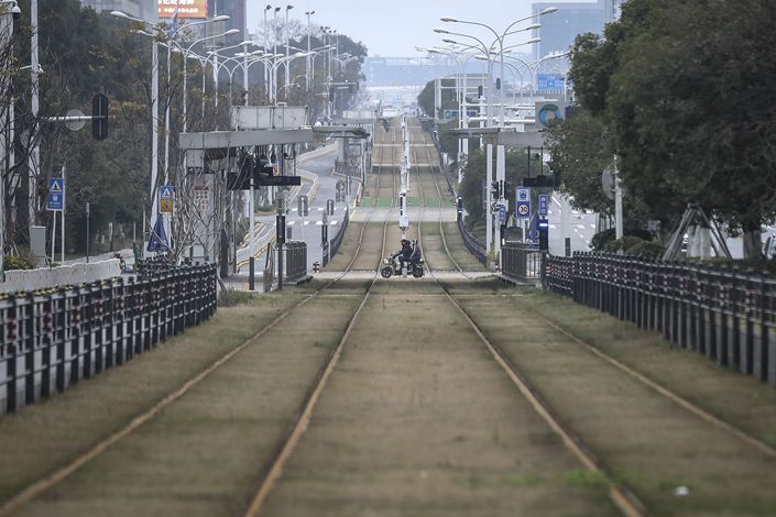 A resident rides a motorbike across an empty track on Feb. 7 in Wuhan, Hubei province. Photo: Bloomberg