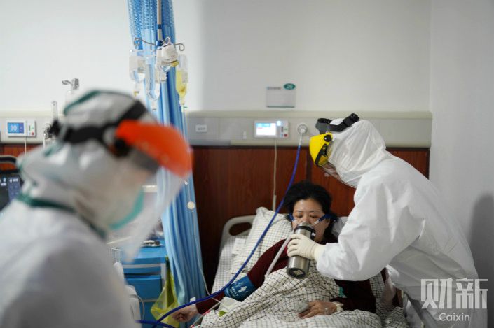 A medical worker cares for a coronavirus patient in Wuhan, Hubei province. Photo: Ding Gang/Caixin