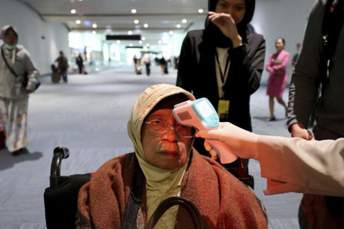 A health official scans the body temperature of a passenger at Jakarta's Soekarno-Hatta International Airport. Photo: AFR