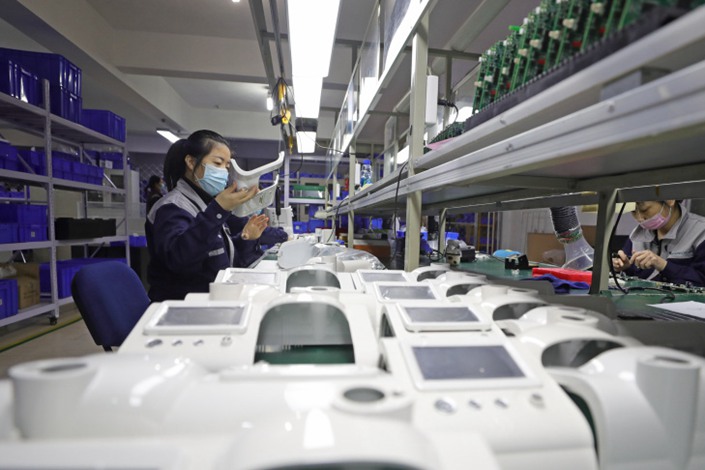 Workers produce non-invasive ventilators in a workshop in Shenyang, Liaoning province, on Jan. 31. Photo: Xinhua