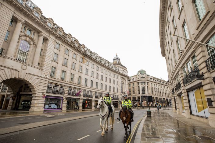 Police officers on horseback ride down Regent Street in London on March. 30. Photo: Bloomberg