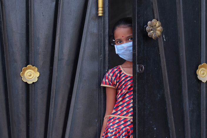 A girl looks out from the gate of her house during lockdown in Hyderabad, India, March 31.