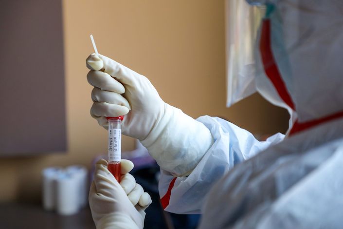 A CDC worker collects biomaterial from suspected patients for nucleic acid tests in Wuhan. Photo: Bloomberg