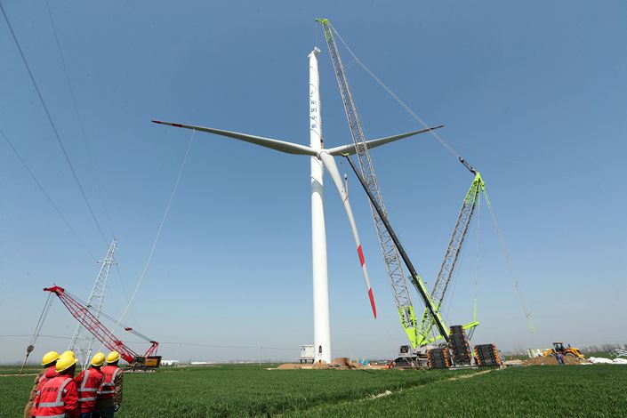 Workers install wind power equipment in Bozhou, Anhui on March 15.