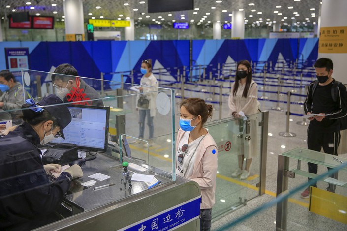 Travellers queue in Shenzhen's Baoan Airport on March 16.