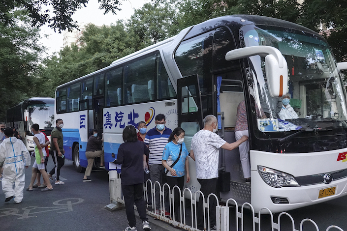 Beijing residents are transported to take Covid-19 tests after outbreak at wholesale market.