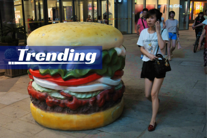 Chinese woman walking past Burger King burger