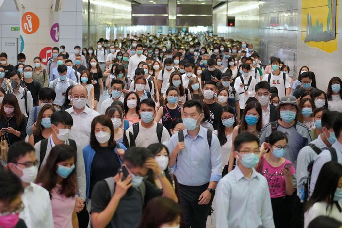 People wearing masks enter a Hong Kong metro station on July 19.