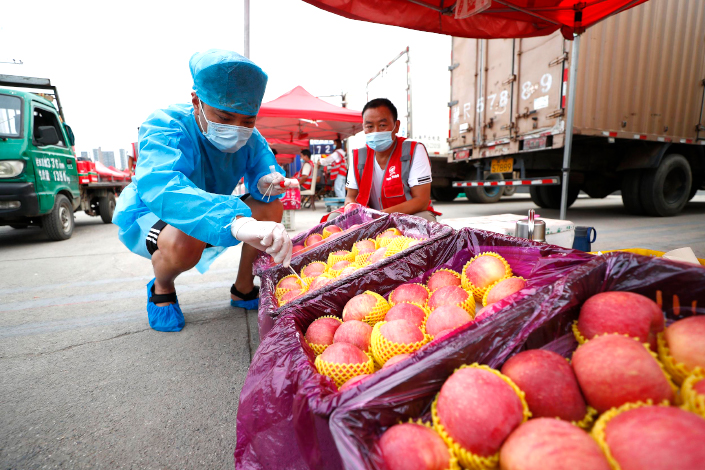 A worker inspects fruit that will be sold in Beijing’s Xinfadi wholesale market. Photo: Fu Tian/China News Service