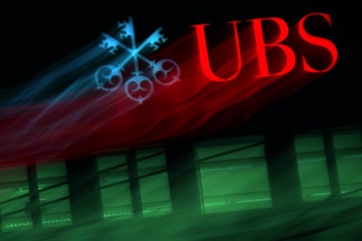 An illuminated company logo is displayed at a UBS Group AG bank branch in Zurich, Switzerland, on Oct. 14, 2019.  Photo: Bloomberg