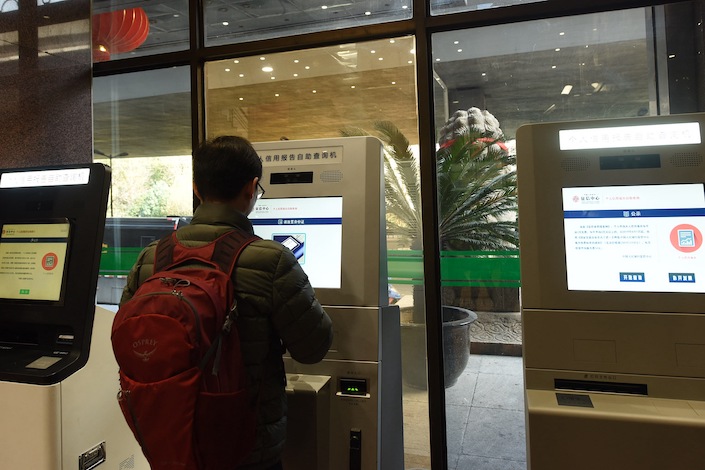 A user checks a personal credit report at a self-service kiosk supported by the PBOC credit reporting system.