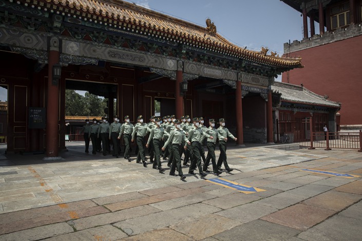 People's Liberation Army soldiers wearing protective masks march past the Forbidden City in Beijing on May 22. Photo: Bloomberg