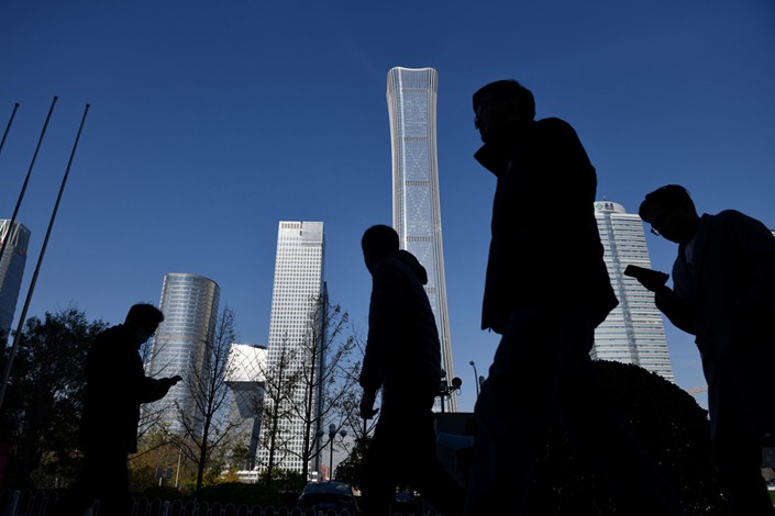 People walk past skyscrapers in the central business district in Beijing. Photo: Bloomberg