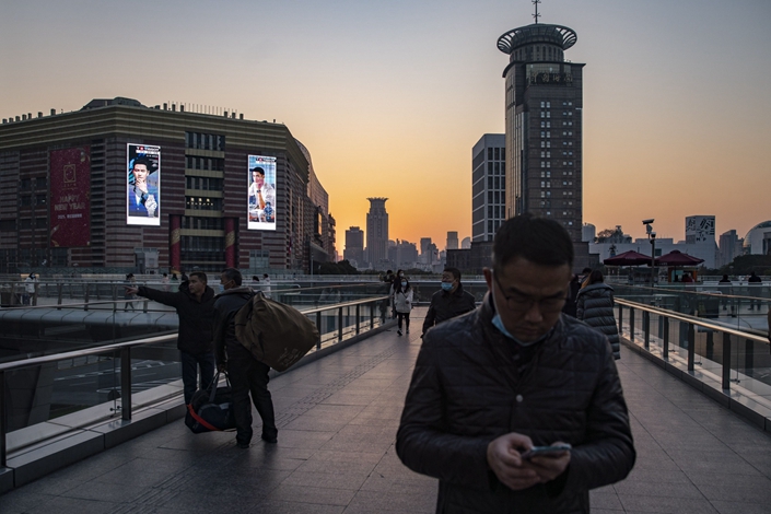 Pedestrians walk on an overpass in Shanghai’s Lujiazui financial district on Monday. Photo: Bloomberg
