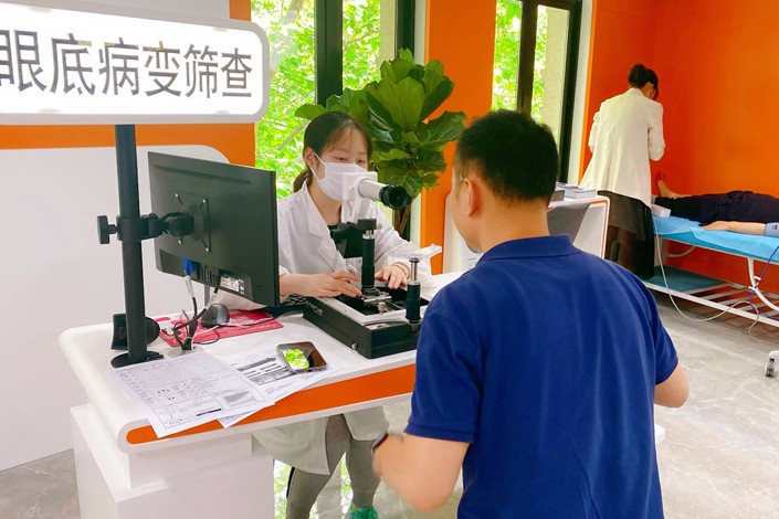 At an Omron health center in Shanghai, a staff member checks a visitor for conditions like glaucoma. Photo: Courtesy of Omron