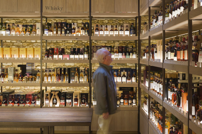 A customer looks at a collection of whiskeys on a shelf at a liquor store in London in 2012.
