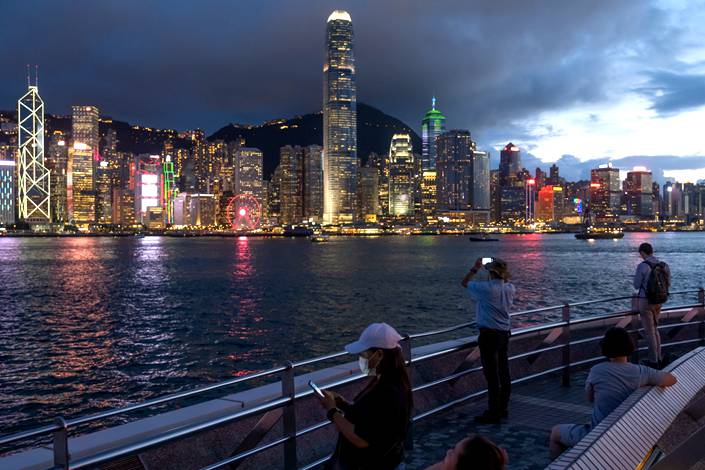 People use their smartphones along the Victoria Harbour waterfront in Tsim Sha Tsui district in Hong Kong on July 7, 2020. Photo: Bloomberg