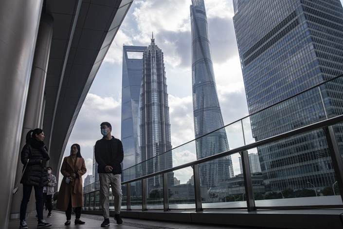 Pedestrians walk through the Lujiazui financial district in Shanghai on Dec. 1. Photo: Bloomberg