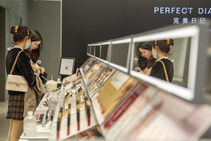 Customers try out cosmetics at a Perfect Diary store in Shanghai on April 15. Photo: VCG