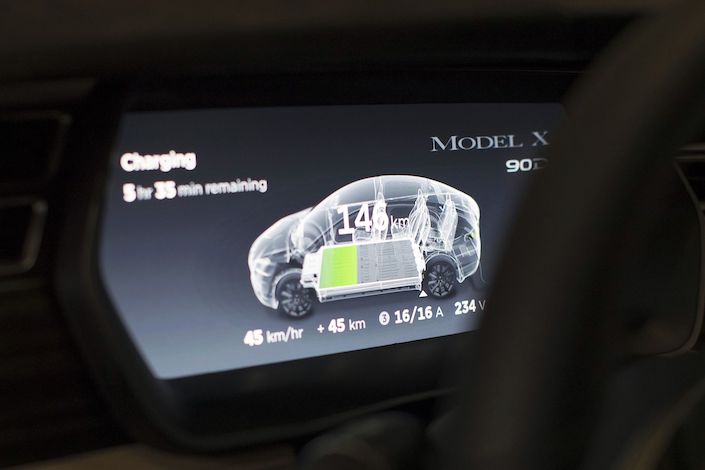 Battery charging status information is displayed on a dashboard screen inside a Tesla Model X sports utility vehicle