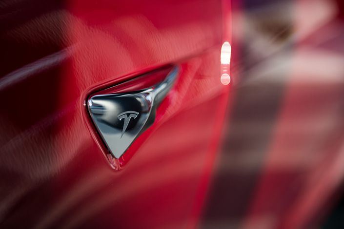 Tesla’s logo is seen on the side-view camera of a Tesla Model S P100D sedan at the company's showroom in New York in December 2017. Photo: Bloomberg