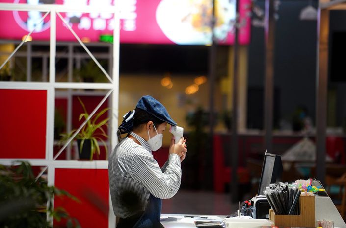A worker takes his temperature at a store in Chengdu East Railway Station in Chengdu, capital of southwest China's Sichuan province, on Jan. 31, 2020. Photo: VCG
