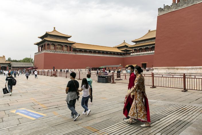 Visitors wearing protective masks walk through the Forbidden City in Beijing. Photo: Bloomberg