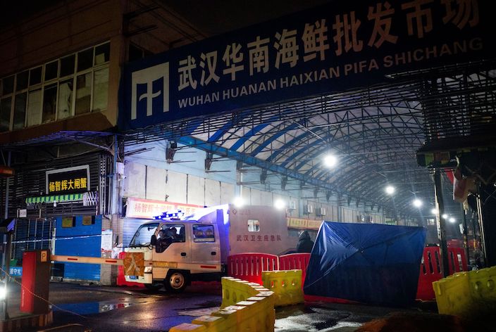 Members of staff of the Wuhan Hygiene Emergency Response Team drive their vehicle as they leave the closed Huanan Seafood Wholesale Market in the city of Wuhan