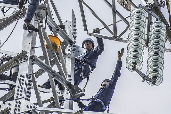 Workers set up a power transmission tower in Foshan, South China’s Guangdong province, in November 2019. Photo: VCG