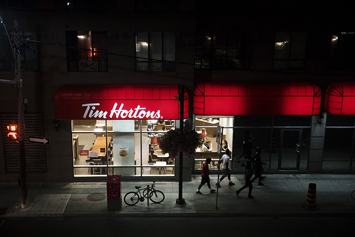 Pedestrians walk past a Tim Hortons in Toronto. Photo: Bloomberg