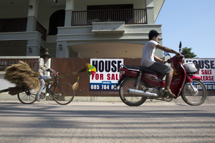 A motorcyclist and a cyclist ride past 'House For Sale' signs in Koh Samui, Surat Thani province, Thailand, on Jan. 18, 2018.  Photo: Bloomberg