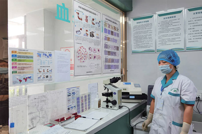 In Bozhou, East China’s Anhui province, a medical worker stands in a hospital laboratory, where microscopic examination of a parasite that potentially causes malaria in humans can be carried out. Photo: Ma Danmeng/Caixin