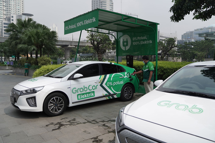 A GrabCar driver charges an electric vehicle in Jakarta, Indonesia, on April 20. Photo: VCGPhoto: VCG