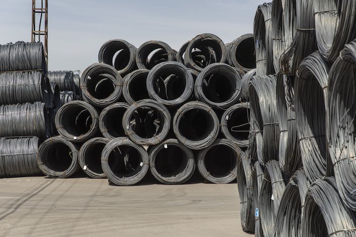 Coils of steel reinforcing bar sit in a metal stock yard in Shanghai on June 7. Photo: Bloomberg