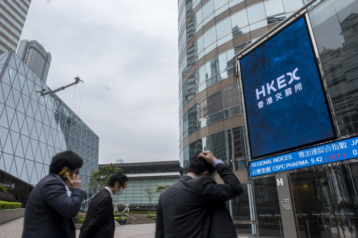 Pedestrians walk past the Exchange Square complex, home to the Hong Kong Stock Exchange, on March 23. Photo: Bloomberg