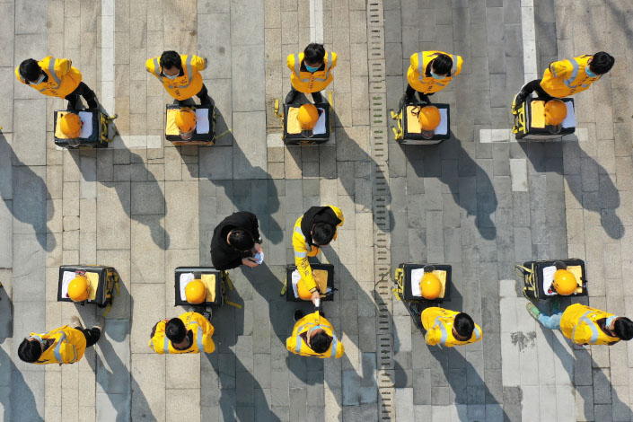 Delivery drivers line up to have their temperatures taken in February 2020 in Changsha, Central China’s Hunan province.