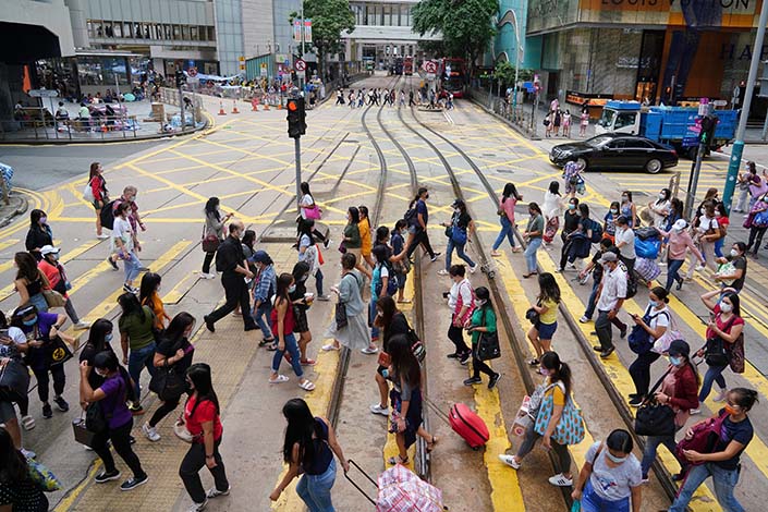 Pedestrians cross the street in Hong Kong’s Central district on Oct. 14. Photo: Zhang Wei, China News Service/VCG