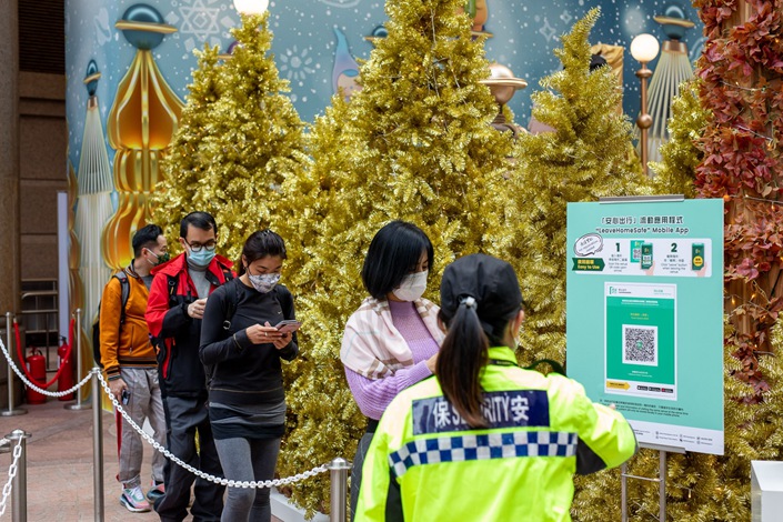 Visitors wait in line to scan a QR code for the LeaveHomeSafe Covid-19 contact-tracing app in Hong Kong on Dec. 7. Photo: Bloomberg