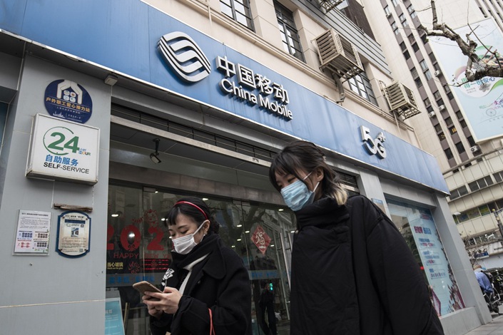 Pedestrians walk past a China Mobile store in Shanghai on Jan. 6. Photo: Bloomberg