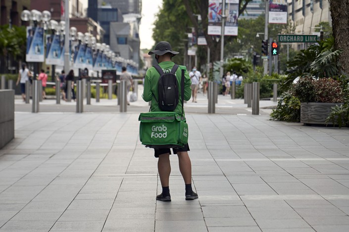 A Grab food delivery rider picks up orders on Orchard Road in Singapore on April 13. Photo:  VCG