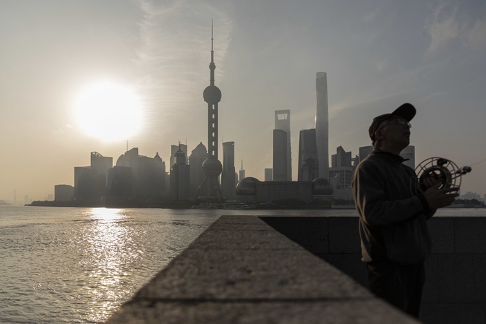 A man flies a kite on the Bund against the backdrop of Shanghai's Lujiazui Financial District on April 10. Photo: Bloomberg